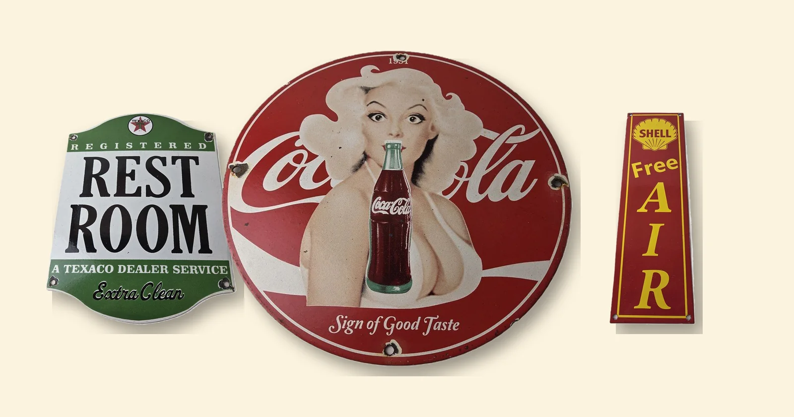Coca-Cola, Texaco Rest Room and Shell Free Air porcelain signs showing the glossy fired enamel that sets porcelain vs tin signs apart