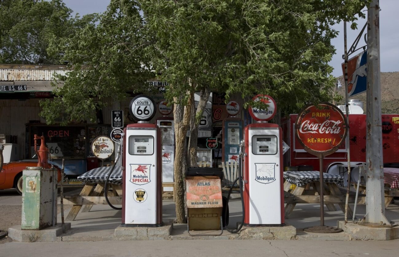 Color photo of vintage gas pumps, a Route 66 shield and a Coca-Cola sign outside the Hackberry General Store in Arizona