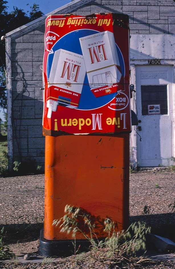 Color photo of an old orange gas pump with a worn sign on Route 66 in Amarillo, Texas