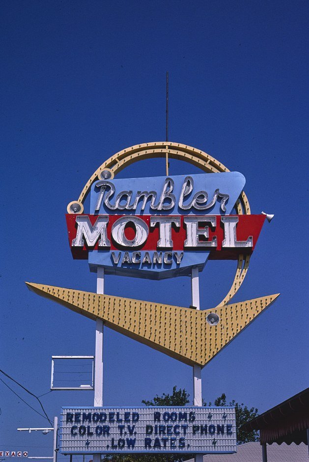 Color photo of the Rambler Motel roadside sign against a blue sky in Shamrock, Texas